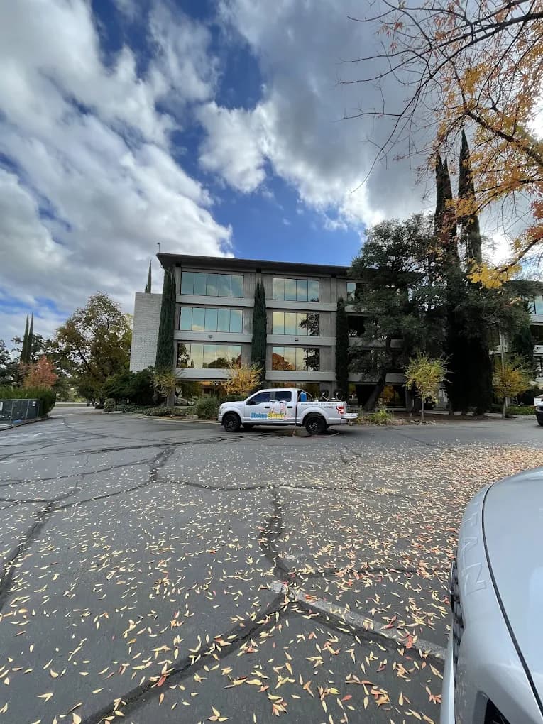 A freshly cleaned multi-story commercial building with a Divine Shine truck parked out front